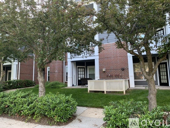 A brick building with a white bench in front of it.