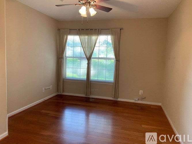 A room with a ceiling fan and sliding glass doors.