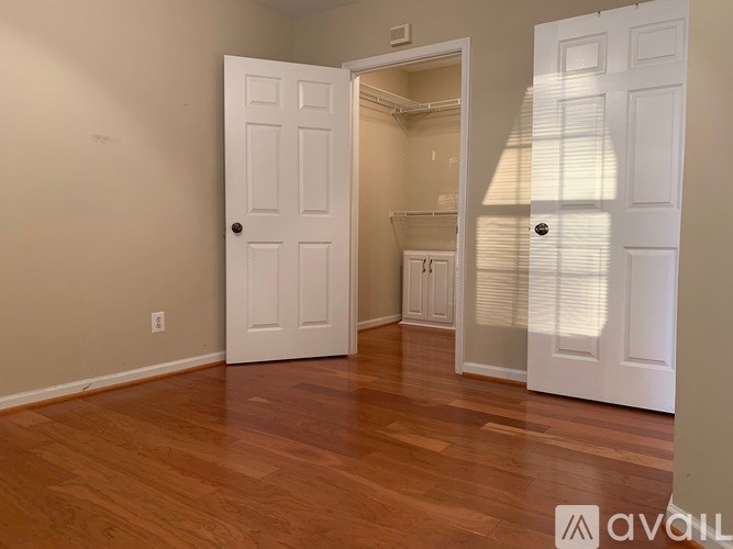A room with wooden floors and a white door.