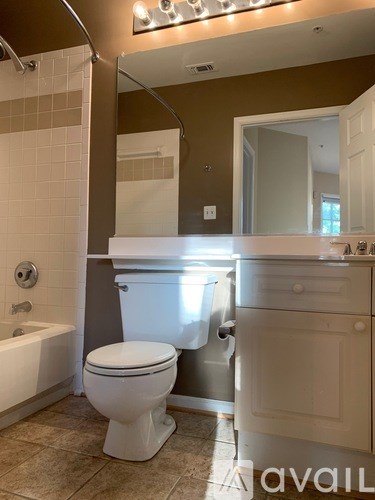 A white toilet sits in a bathroom with brown walls.