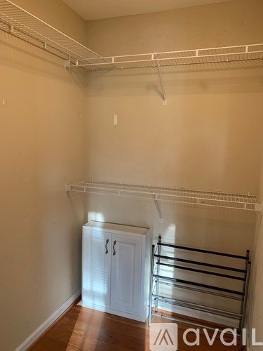 A white closet with a shelf and a white door.