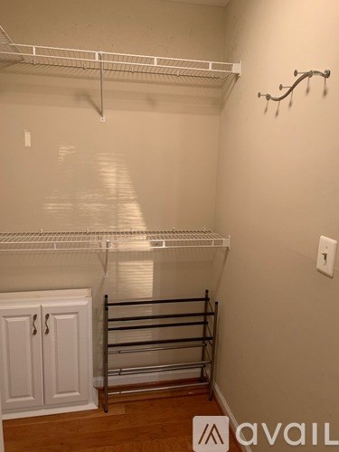 A white closet with a shelf and a cabinet.