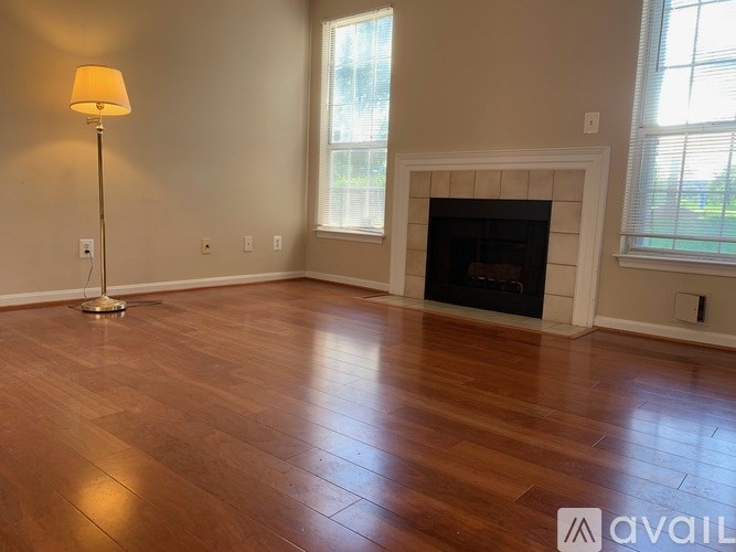 A living room with a fireplace and a lamp.