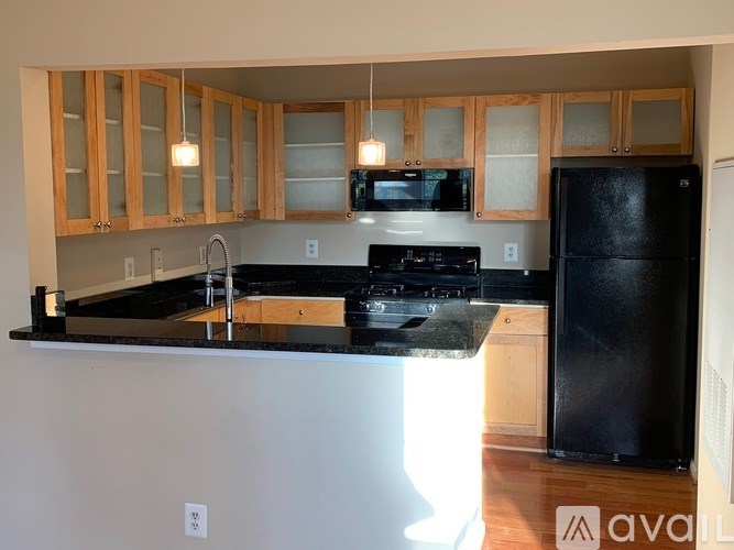 A kitchen with black countertops and wooden cabinets.