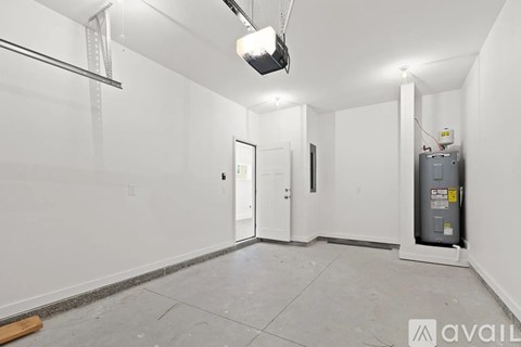 A spacious empty room with a door, a window, and a white wall.