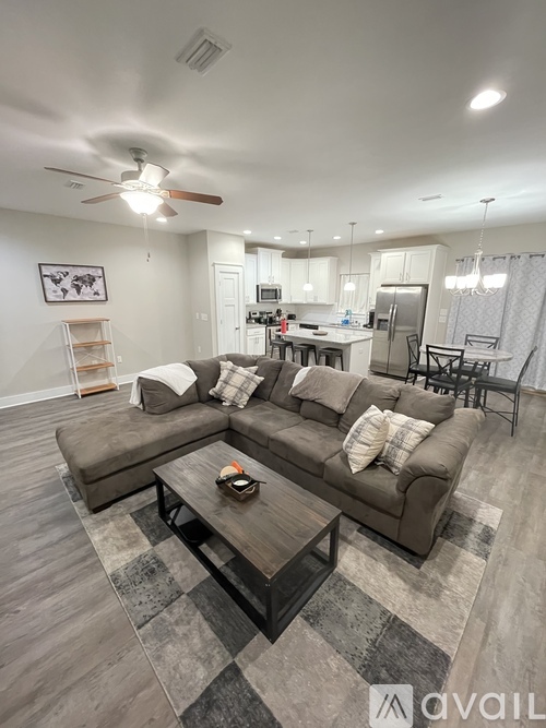 A living room with a grey couch and a coffee table in the middle.
