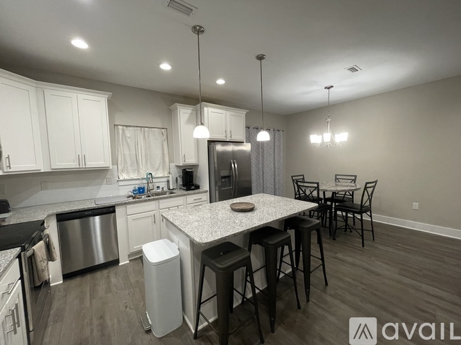 A kitchen with a granite countertop and a dining table with chairs.