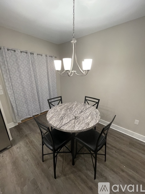 A dining room with a round marble table and chairs.