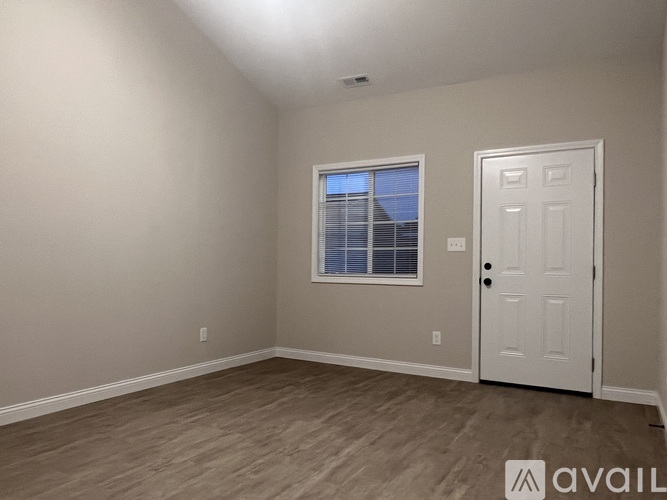 A room with a white door and a window with blinds.