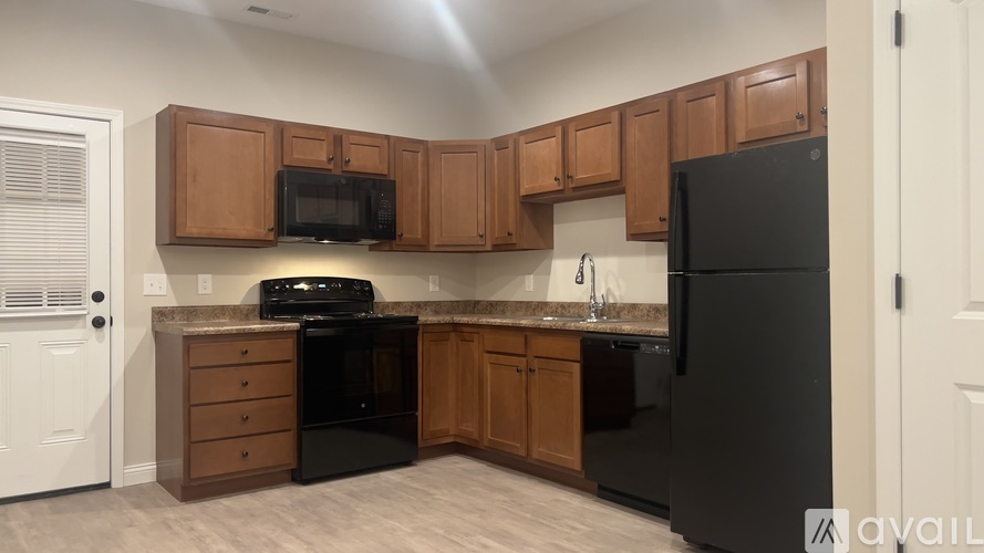 A kitchen with black appliances and wooden cabinets.