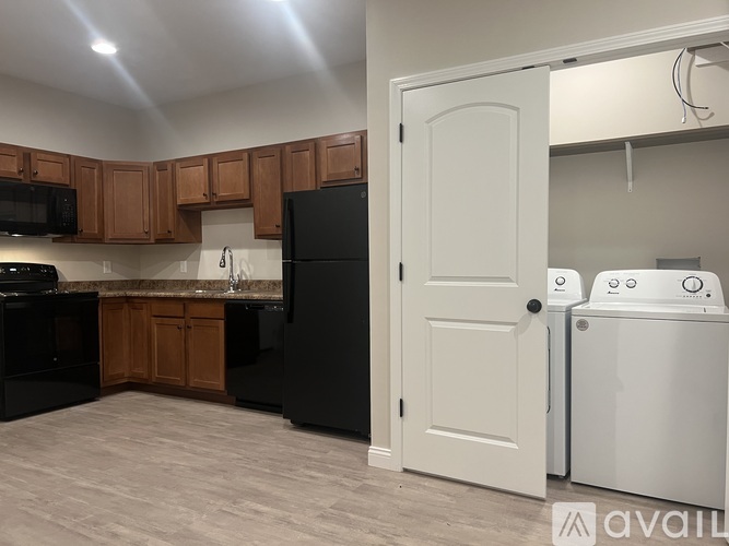 A kitchen with black appliances and wooden cabinets.