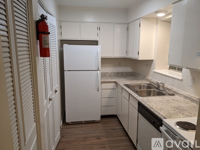 A kitchen with white appliances and cabinets.