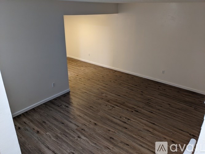 A room with wooden flooring and white walls.