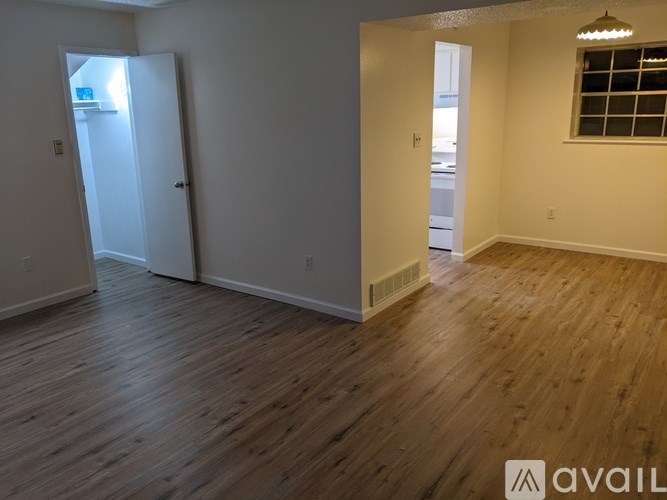 A room with wooden floors and a window with bars on it.