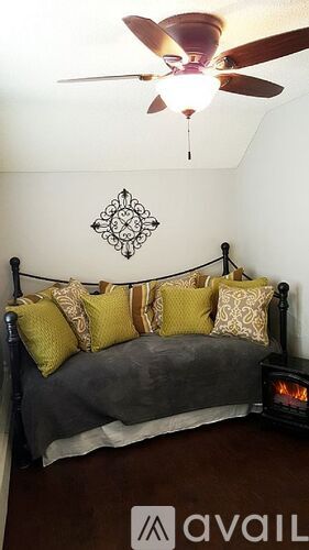 A bedroom with a bed and a ceiling fan.