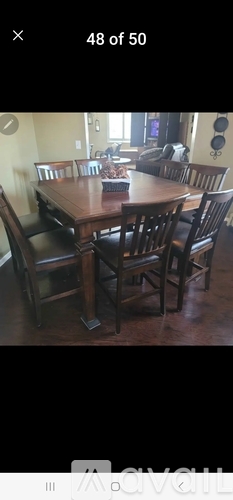 A dining room with a wooden table and chairs.