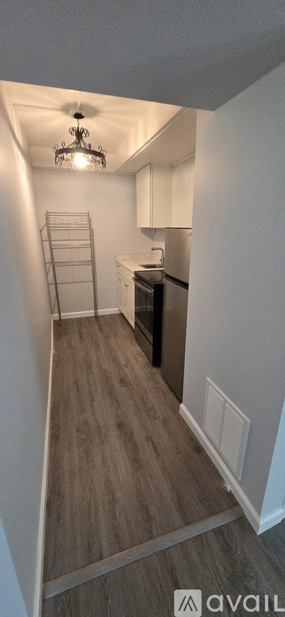 A kitchen with a refrigerator, stove, and a chandelier.