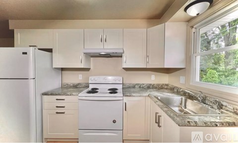 A kitchen with white appliances and cabinets.
