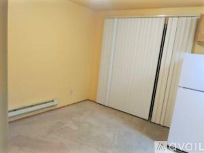 A room with a white door and a white refrigerator.