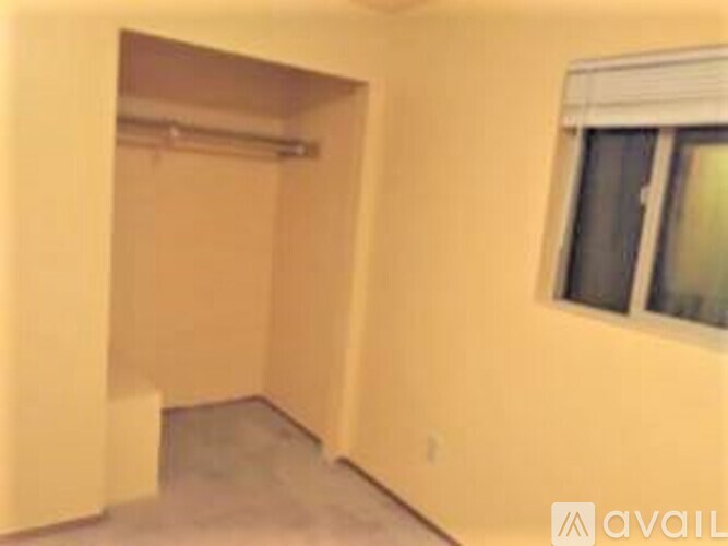 A room with a window and a doorway leading to another room.