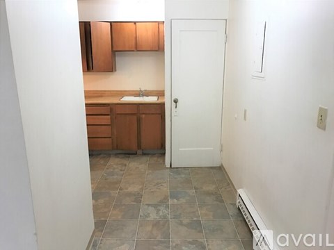 A kitchen with brown cabinets and a white door.