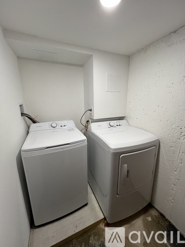 Two white washing machines in a small room.