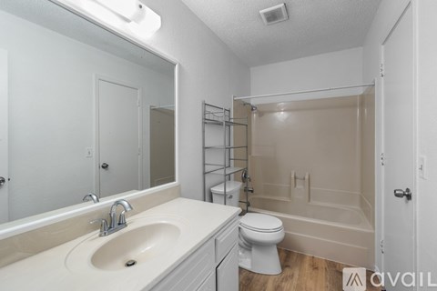 A bathroom with a sink, toilet, and bathtub.