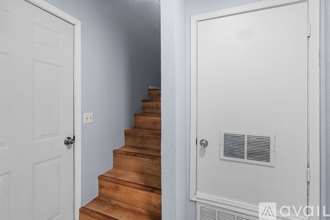 A white door is on the left and a white door with a vent is on the right.