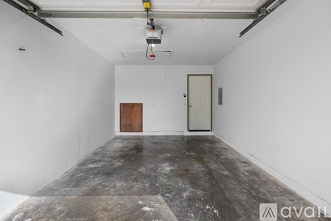 A room with a concrete floor and two doors, one of which is closed.