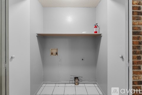 A white bathroom with a shelf and a bottle of lotion on it.