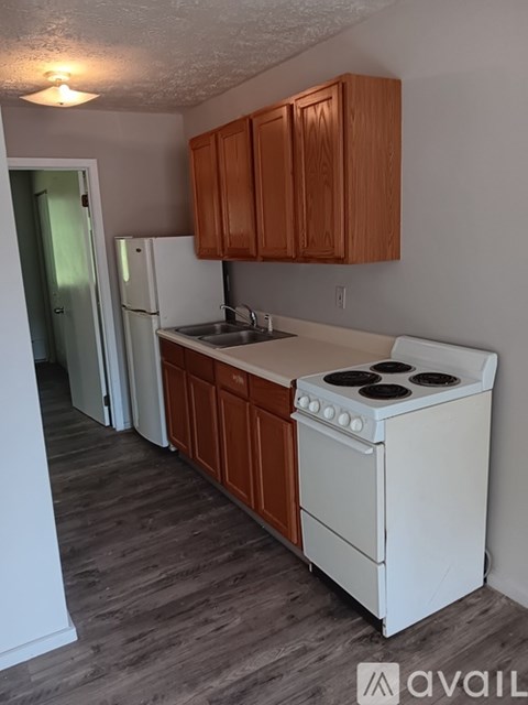 A kitchen with white appliances and brown cabinets.