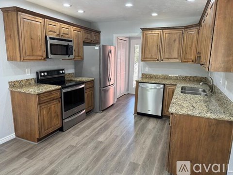 A kitchen with wooden cabinets and granite countertops.