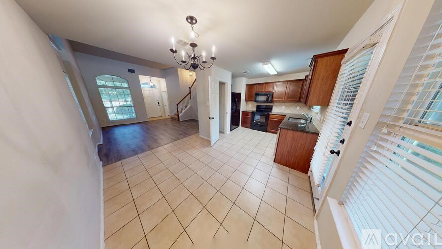 A kitchen area with a refrigerator, a door, and a chandelier.