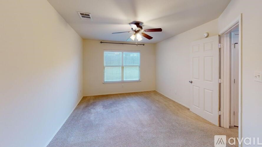 A room with a ceiling fan and a window with blinds.