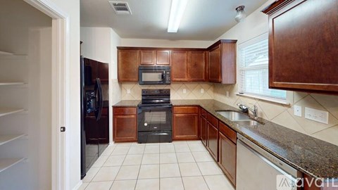A kitchen with brown cabinets and a black oven.