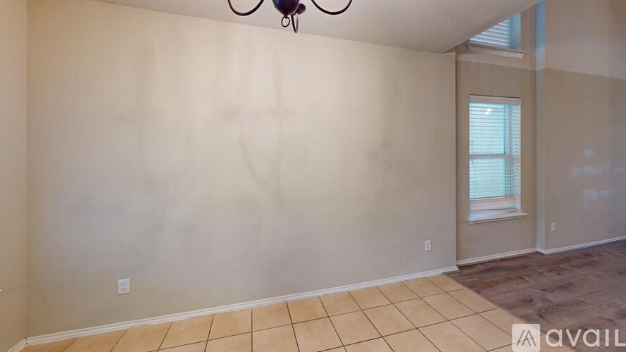 A room with a tiled floor and a window with blinds.