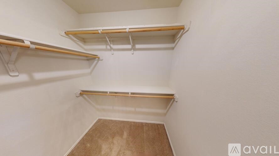 A room with a carpeted floor and a window with blinds.