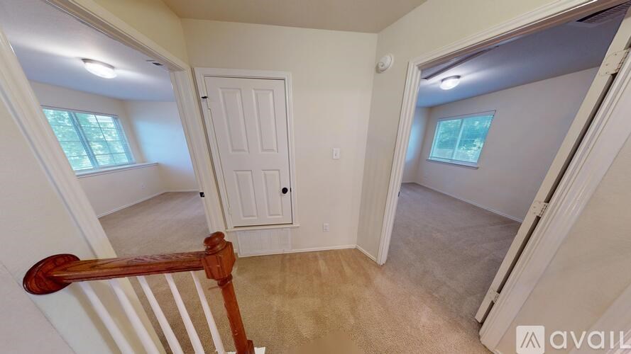 A room with a carpeted floor and a window letting in natural light.
