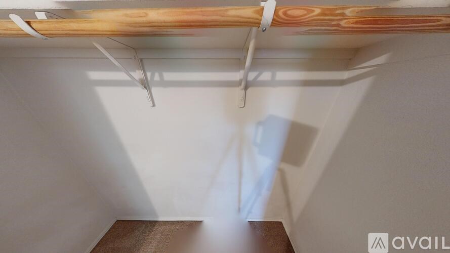 A room with a wooden beam on the ceiling and white walls.