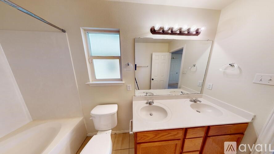 A bathroom with a tub, toilet, sink and mirror.