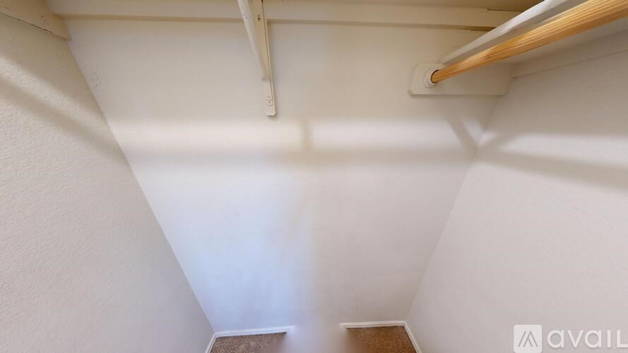 A small room with a wooden shelf and a white wall.