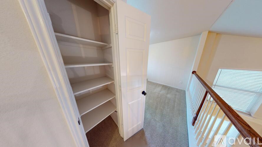 A white door is open to a hallway with a staircase.