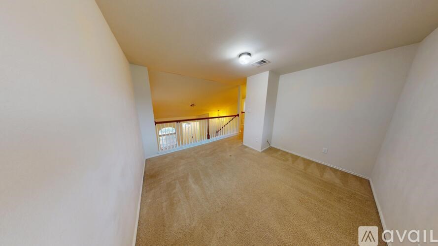 A room with a carpeted floor and a small balcony with a railing.