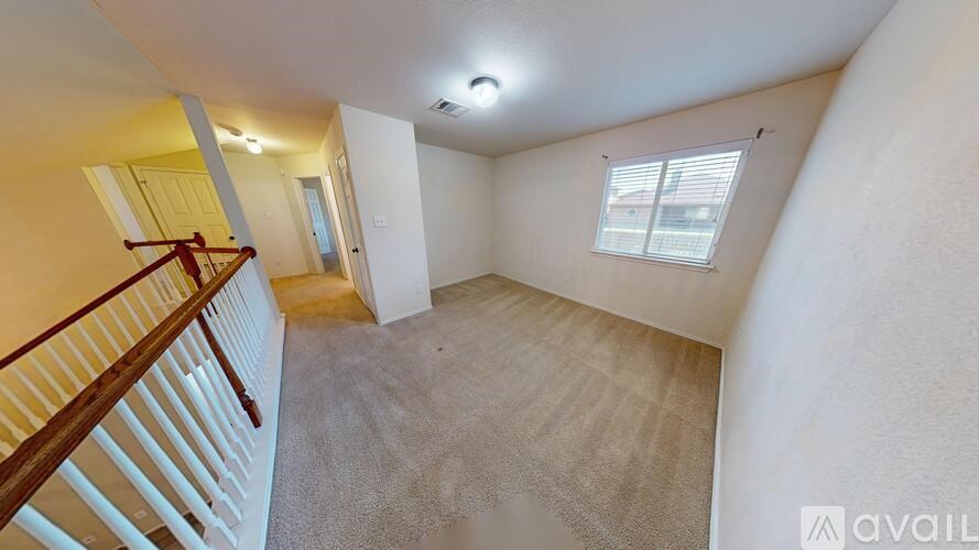 A room with a carpeted floor and a window with blinds.