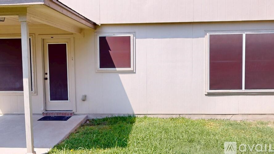 A house with a white wall and a brown door.