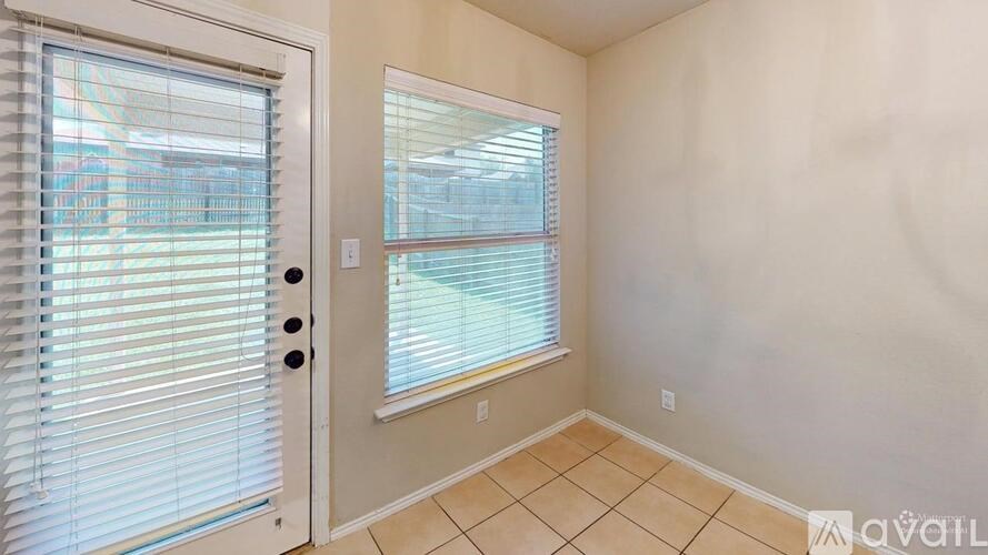 A room with a door and a window with blinds.