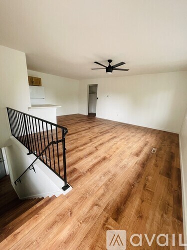A room with wooden flooring and a ceiling fan.