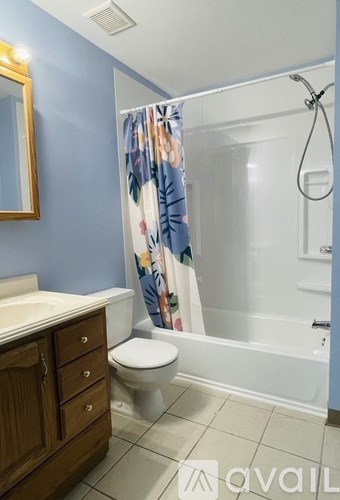 A bathroom with a toilet, sink, and shower.
