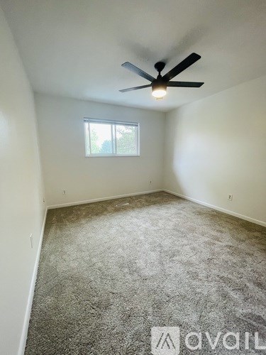 A room with a ceiling fan and a window.