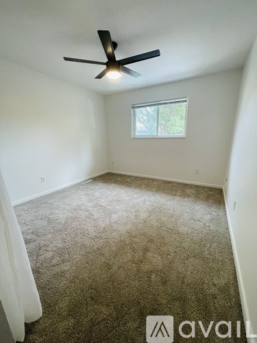 A room with a ceiling fan and a window.